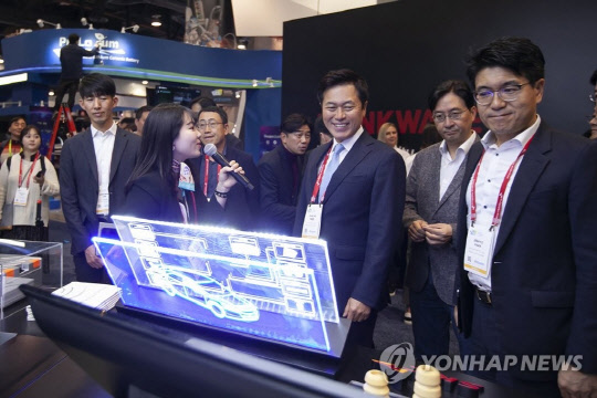 박정호(가운데)SK텔레콤 사장이 올 초 미국 라스베이거스 컨벤션센터에서 열린 'CES 2019'에서 SK 공동 부스에 전시된 아이템을 둘러보고 있다.   연합뉴스·LG유플러스 제공